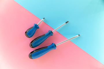 Screwdriver set, flat lay. Set of screwdrivers. Blue red background top view pattern copy space