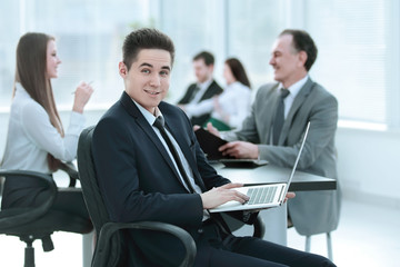 Portrait of handsome young business man and laptop