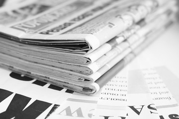 Latest news in pile of fresh morning newspapers with headlines and articles, business paper...