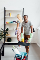 mature couple doing housecleaning in living room together