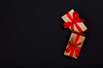 Gift boxes with red ribbons on black background.