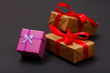 Gift boxes tied with ribbons on black background