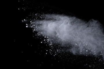 White powder explosion on black background. Dust splatted isolated. Paint Holi.