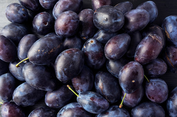 Plums background. Top view. Vegetarian or healthy eating. Blue food.