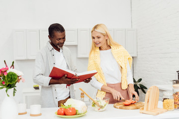 happy couple cooking dinner together at kitchen