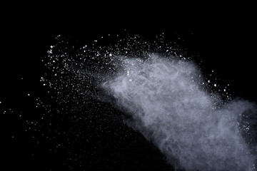 White powder explosion on black background. Dust splatted isolated. Paint Holi.