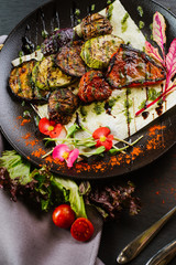 Vegan dish with roasted vegetables on black background