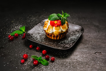 Sweet cupcake with cranberry on black background