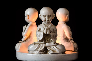 Ancient figurine with three monks in meditation pose