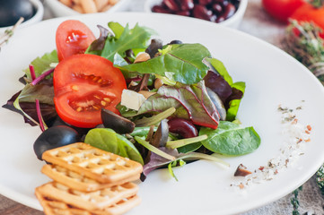 Salad for the correction of the weight of the leaves of Lollo Rosso lettuce, watercress salad and other green herbs with tomatoes, olives and phytacs