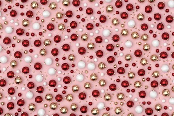 Minimal christmas background pattern. Scattered red, gold, white decoration balls and stars on pastel pink background. 3D rendering.