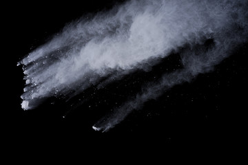 White powder explosion on black background. Dust splatted isolated. Paint Holi.