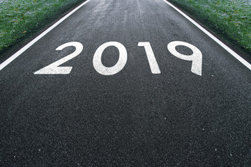 Conceptual new Year 2019 on the dark asphalt road background.