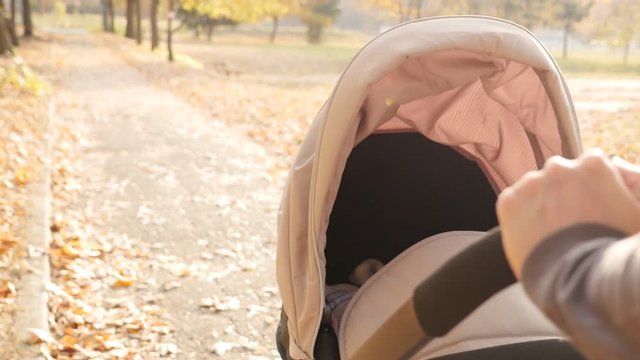 Mom with stroller handle grip in hands slow motion footage