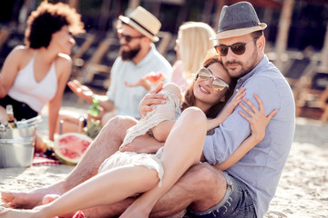 Young couple enjoying picnic on beach together