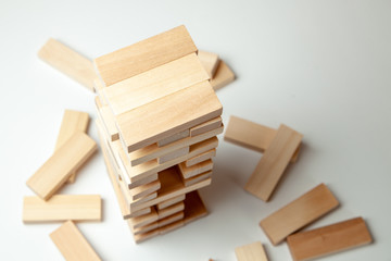 Tower of wooden blocks on gray background. Board game for the whole family or party. Concept of building business or building team.