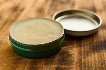 Organic balm in open small metal can, lid to the side. - obrazy, fototapety, plakaty