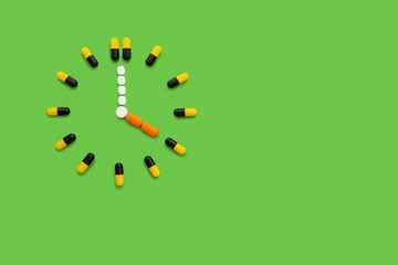 The pills clock isolated on green background