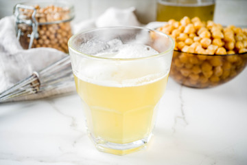 Chickpea broth aquafaba, liquid water brine, Replace egg in baking for vegan recipe. Vegan diet drink, white marble background copy space