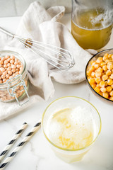 Chickpea broth aquafaba, liquid water brine, Replace egg in baking for vegan recipe. Vegan diet drink, white marble background copy space