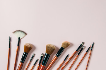 Professional makeup tools brushes on a pastel pink background. magazines, social media. Top view. Flat lay. Copy space