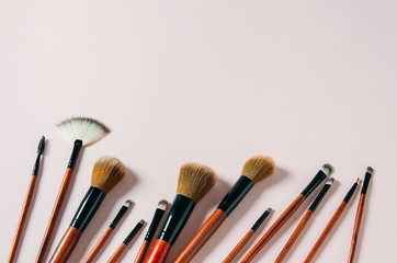 Different makeup brushes on pastel pink background. Copy space. Magazine, social media. Beauty and Fashion