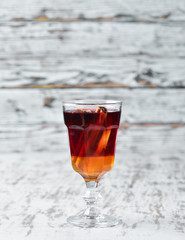 Hot cocktail of red wine, honey and cinnamon. On a wooden background. Top view. Free copy space.