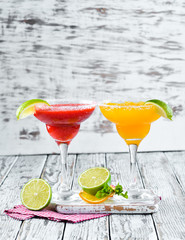 Two alcoholic cocktails Margarita. On a wooden background. Top view. Free copy space.