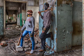 A pair of cyberpunk hooligans: a girl in gas mask and steampunk goggles with a bat and a guy in skull mask with a sledgehammer, standing in the middle of the ruins of an old building. street band