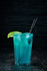 Blue Alcoholic Cocktail. On a wooden background. Top view. Free copy space.