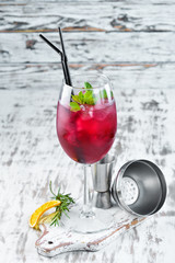 Flamingo Cocktail. Liquor currants, blackberries and mint. Alcoholic cocktail in a glass. On a wooden background. Top view. Free copy space.
