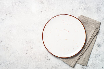 White craft plate and napkin on white stone table. 