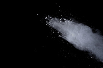 White powder explosion on black background. Dust splatted isolated. Paint Holi.