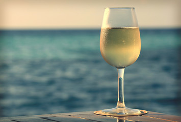 glass of white wine on the beach