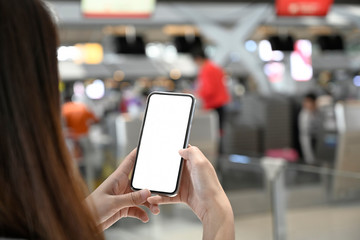 Female hand using mobile phone in check-in counter in airport terminal.