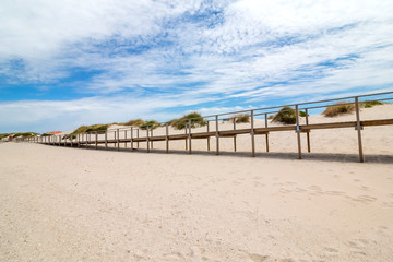 Fototapeta na wymiar Wooden footbridge at the sand beach in Portugal