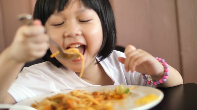 4K Happy Asian child eating delicious spaghetti