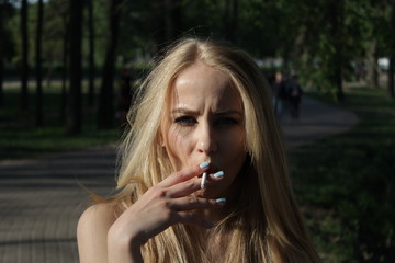 Fototapeta premium young blonde girl who smokes a cigarette
