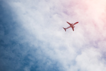 Bottom view of flying airplane in sky with sunlight