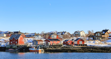 Fototapeta na wymiar Winter and snow - Red fishing pier and fishing boats in Salhus strait in Brnnoy municipality, Northern Norway 