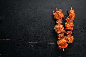 Skewers of barbecue sauce. On a wooden background. Top view. Free space for your text.