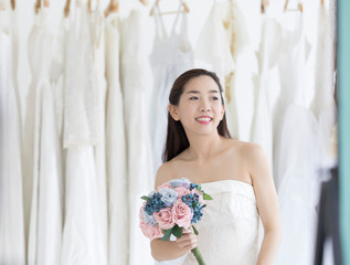Asia woman trying on wedding dress in a shop