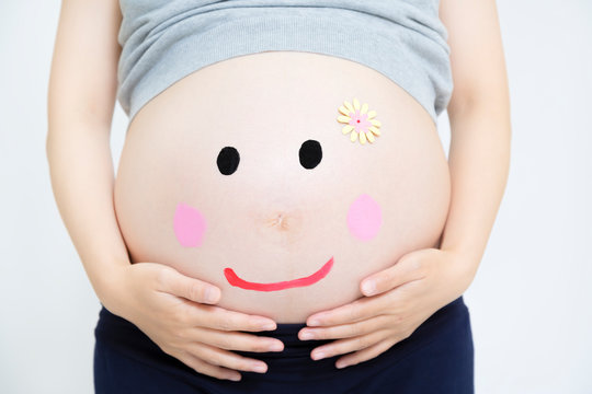 大きなお腹に描かれたマタニティペイント。臨月,妊娠,ベリーペイント,愛,幸せイメージ　