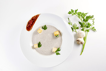 Mushroom cream soup with croutons, herbs and spices over white background close up - homemade vegan vegetarian diet organic meal food soup