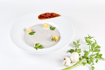Mushroom cream soup with croutons, herbs and spices over white background close up - homemade vegan vegetarian diet organic meal food soup