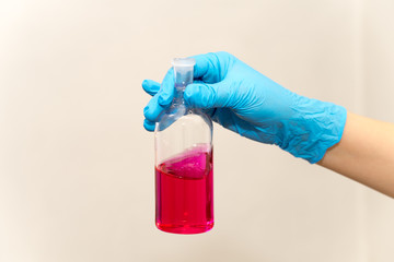 hand in glove holding test tube in the laboratory