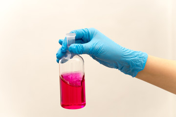 hand in glove holding test tube in the laboratory