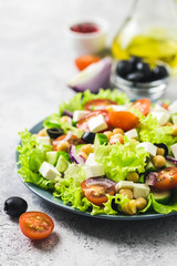 Chickpeas, tomato, cucumber,olives feta salad with lemony dressing. Selective focus, space for text.