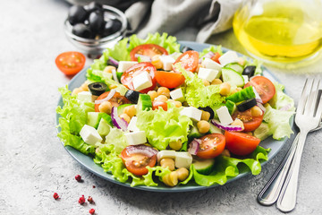 Chickpeas, tomato, cucumber,olives feta salad with lemony dressing. Selective focus, space for text.