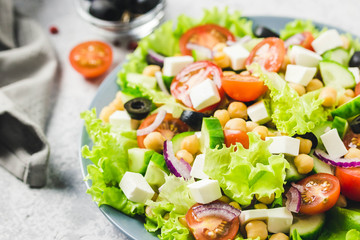 Chickpeas, tomato, cucumber,olives feta salad with lemony dressing. Selective focus, space for text.